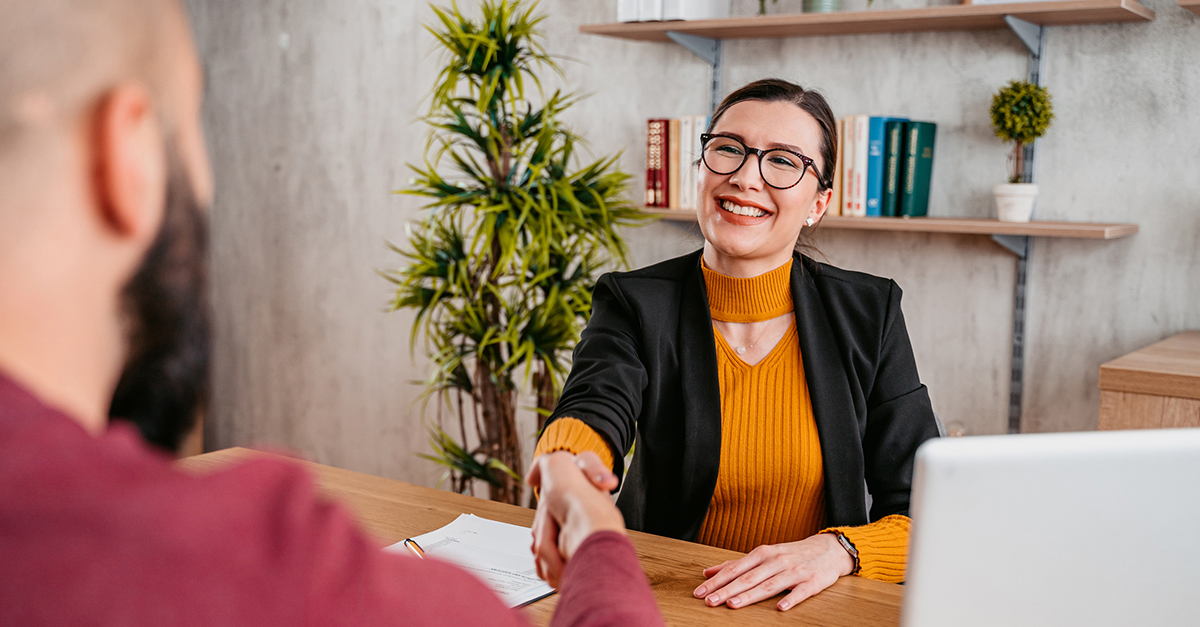 A female agent shakes a client's hand